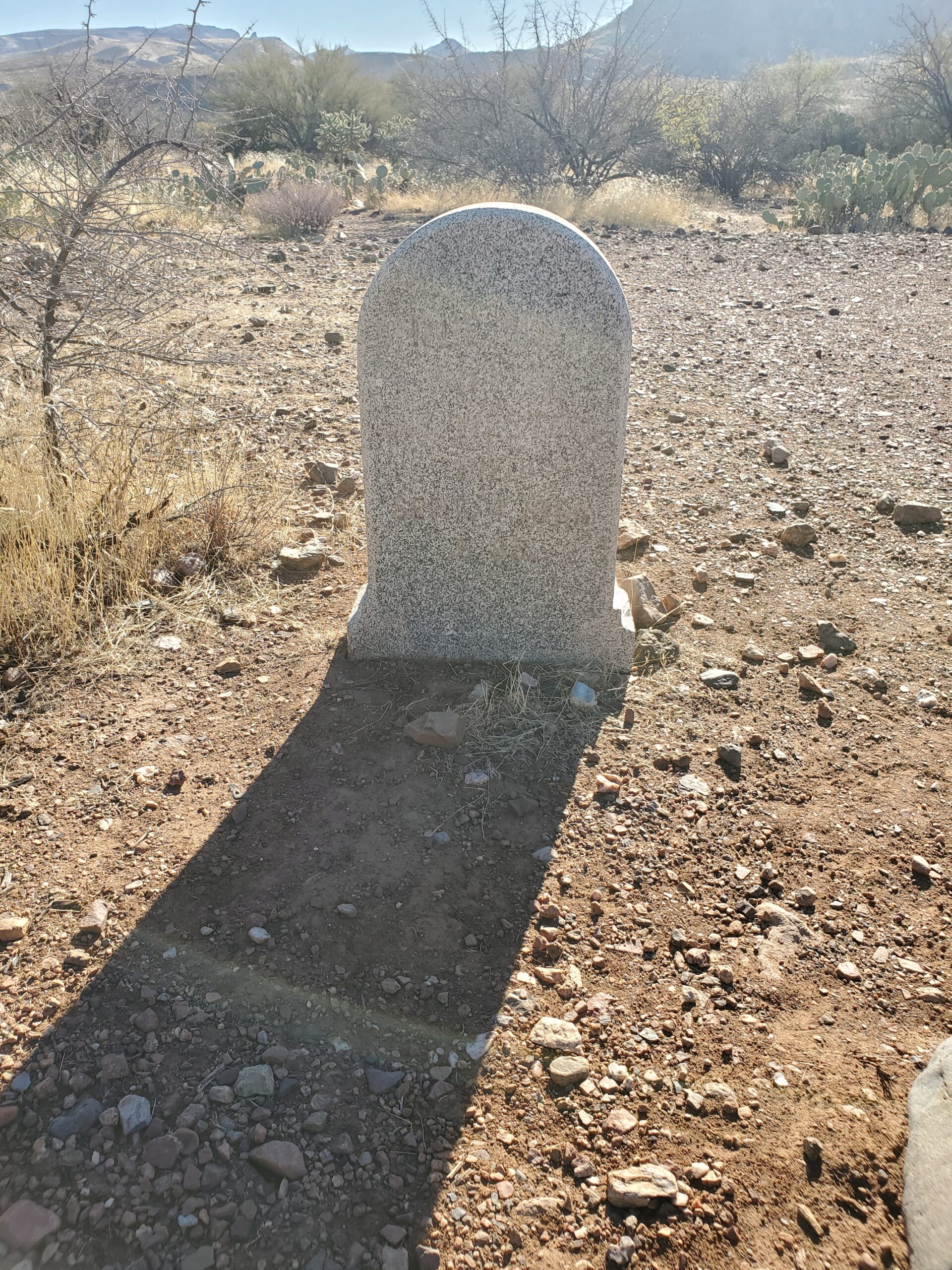 This marble grave marker is nearly impossible to read in the Arizona sun